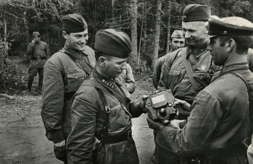Писатели Евгений Петров (первый слева), Михаил Шолохов и Александр Фадеев (второй справа) осматривают приборы, снятые с подбитого фашистского танка. 1941 год